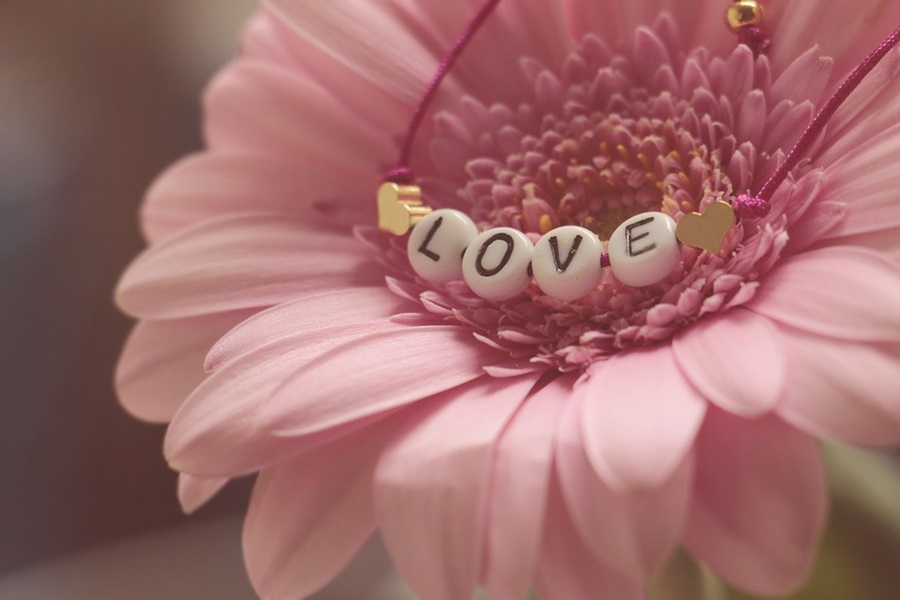 DIY Valentines Day Crafts for Kids a Pink Flower with a Bracelet Hanging Over the Front of it That Says Love