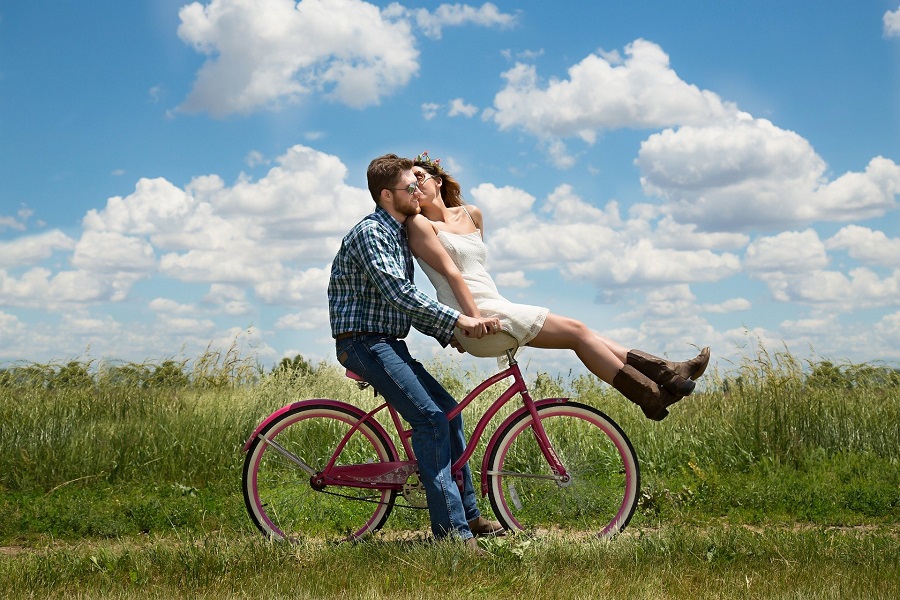 Romantic Valentine's Day Quotes for Him Couple Riding a Bike Across a Field with the Woman on the Handlebars Leaning Back and Kissing The Other Rider