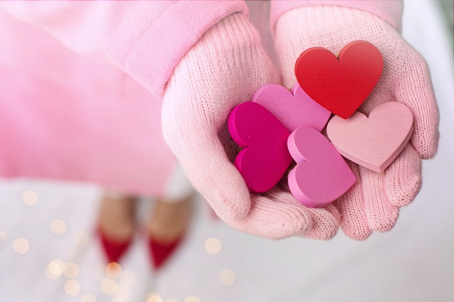 Valentine's Day Party Decorations for Kids Close Up of a Young Girls Hands in Mittens Cupped Together Holding Red and Pink Hearts