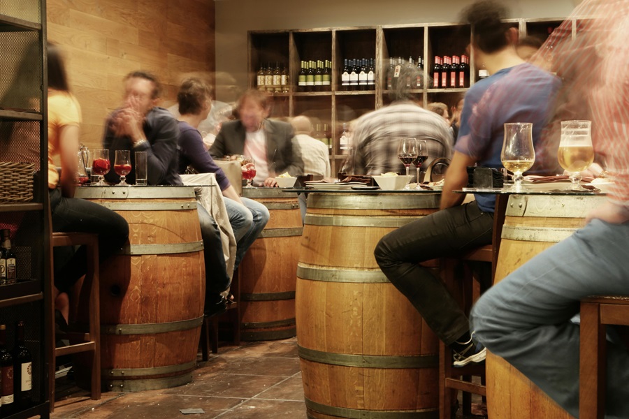 Wine Tasting Tips you Need to Know a Winery with Wine Barrels and People Sitting Around Them Tasting Wine