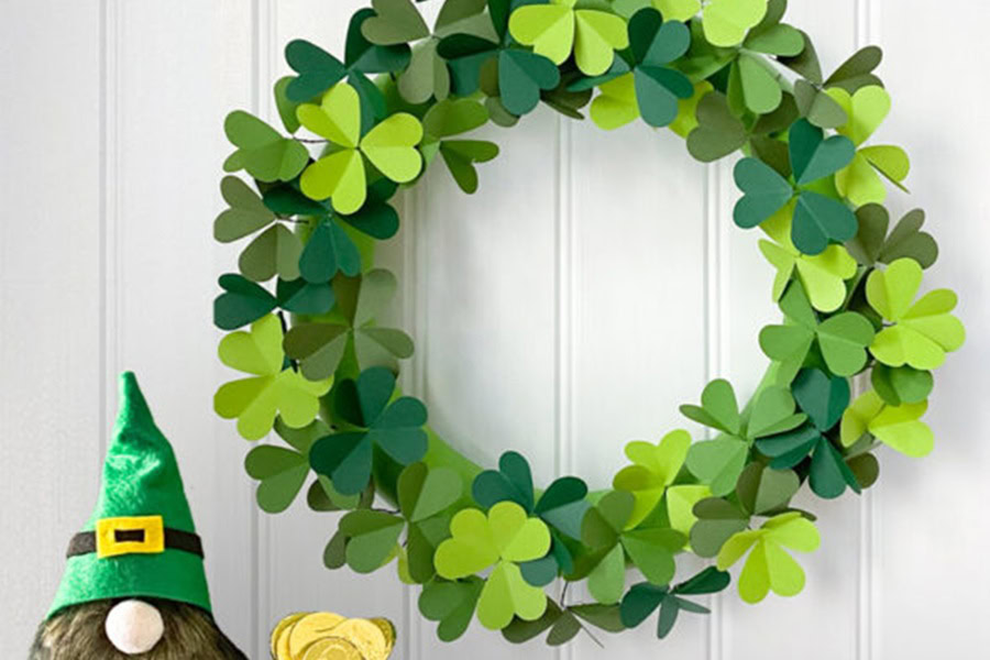 Creative St Patricks Day Decorations on a Budget a Paper Clover Wreath Hanging on a Wall with a Small Leprechaun Doll Next to it