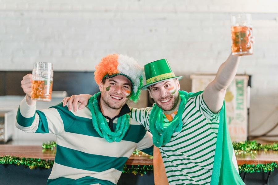St Patricks Day Quotes to Celebrate the Irish Spirit Two Guys Dressed in Green Striped Shirts and Wearing Funny Hats Raising a Glass of Beer