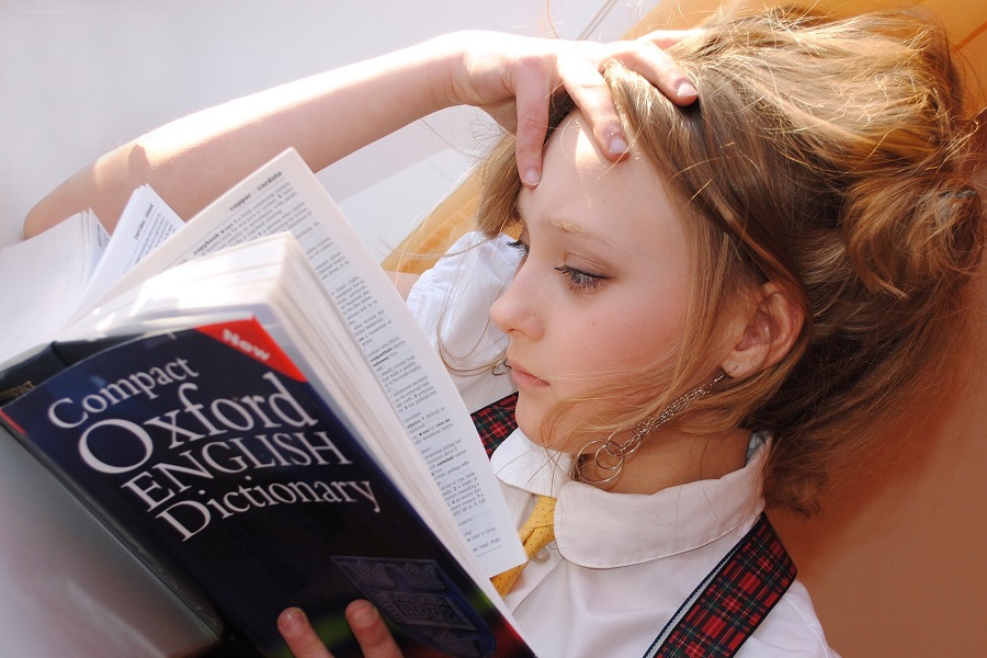 Quotes About New Beginnings for Students Female Student Laying Down Reading the Oxford Dictionary