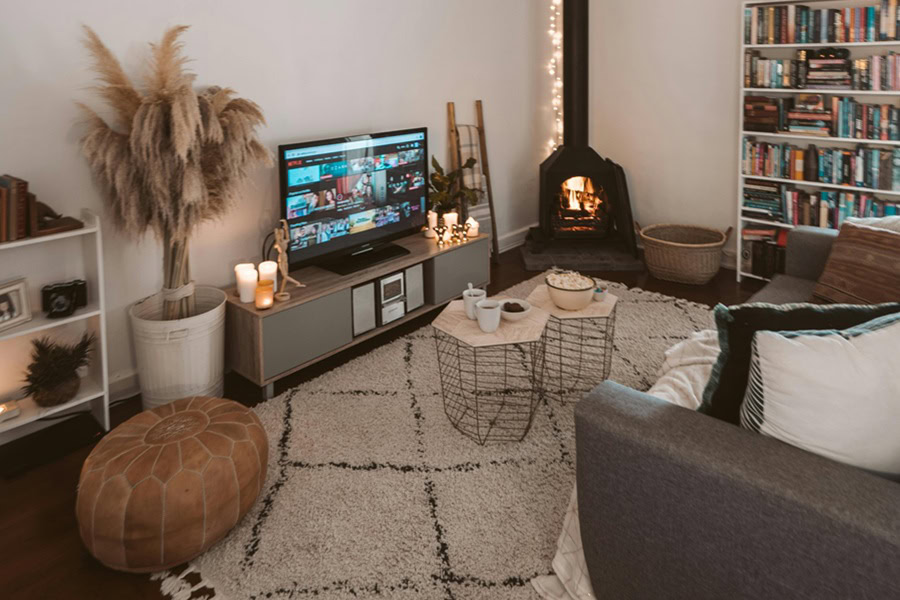 Netflix Shows Best Shows to Watch for All Ages Netflix on a TV in a Living Room with a Fireplace and Plants