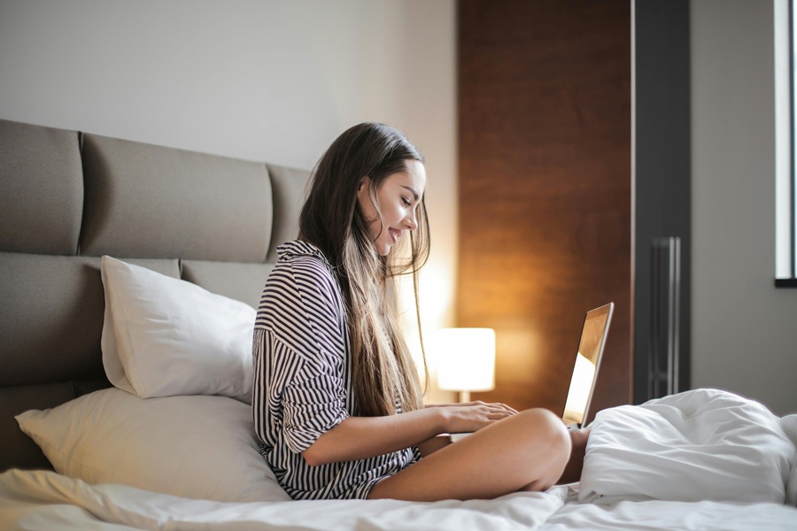 Netflix Shows for Teen Girls a Girl Sitting on a Bed Looking at a Laptop on Her Lap