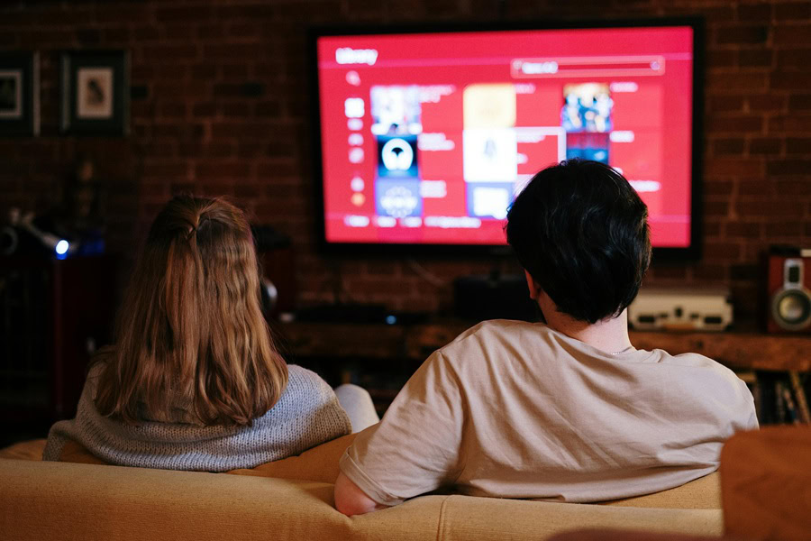 Netflix Shows for Teen Girls a Couple Sitting on a Couch Watching Netflix on TV