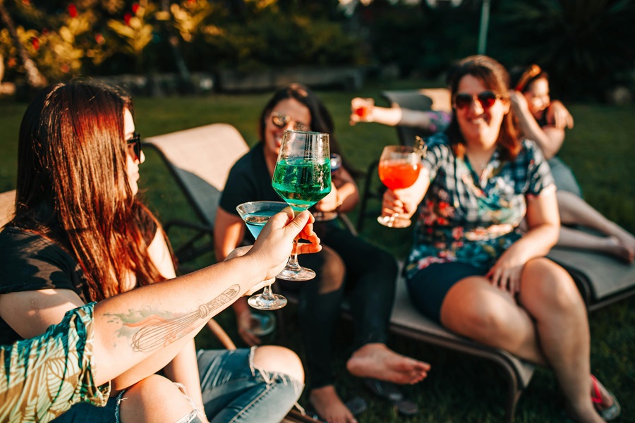 Best Backyard Games for Parties Four Women Sitting in Lawn Chairs Toasting with Cocktails