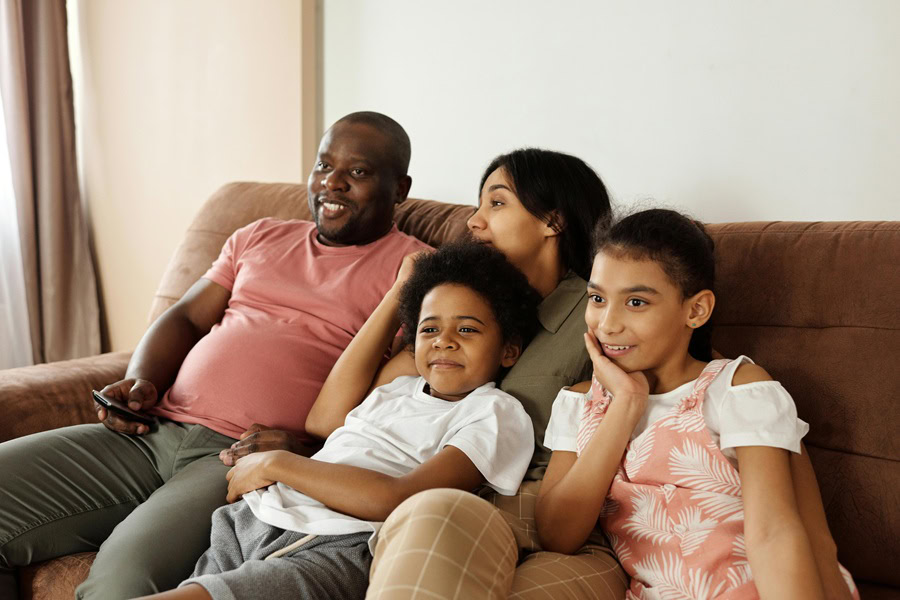 Family Friendly Movies to Watch at Home a Family Sitting on a Couch Watching TV Together