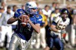 Football Party Ideas A Quarterback Playing Football in a Blue Jersey with a White Helmet and a Crowd of People Behind Him