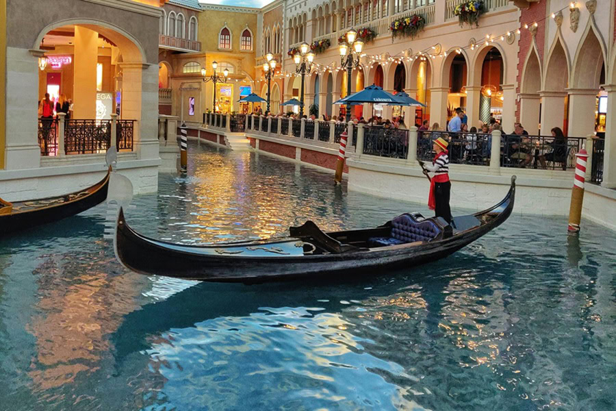 Free Things to Do in Las Vegas for Couples a Man Using a Stick to Push a Long Boat on Water to Mimic Venice, Italy Indoors in Vegas