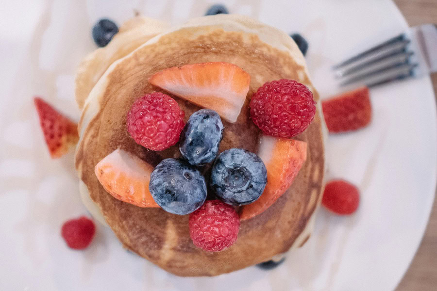 Easy Instant Pot Breakfast Recipes Overhead View of a Stack of Pancakes Topped with Fresh Berries