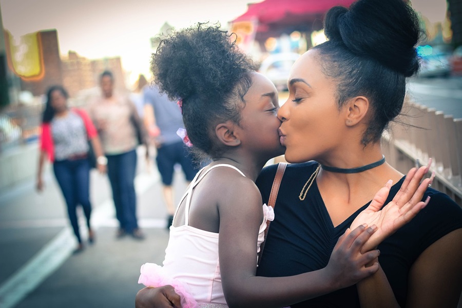 Free Things to Do in Orange County with Kids Close Up of a Mom and Daughter Hugging and Kissing Each Other on the Cheek