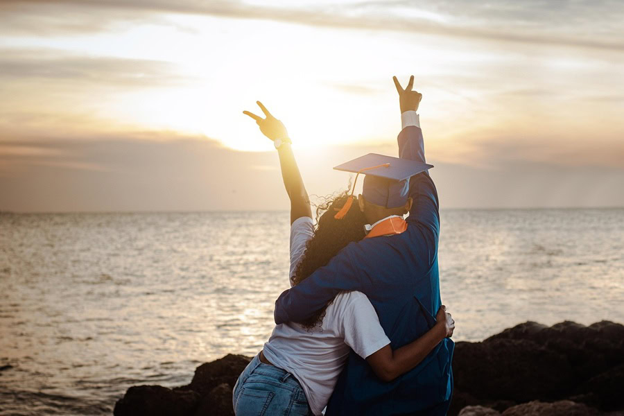High School Graduation Party Foods a Grad and His Mother Standing with Their Backs Turned Toward the Camera Looking Out at a Sunset