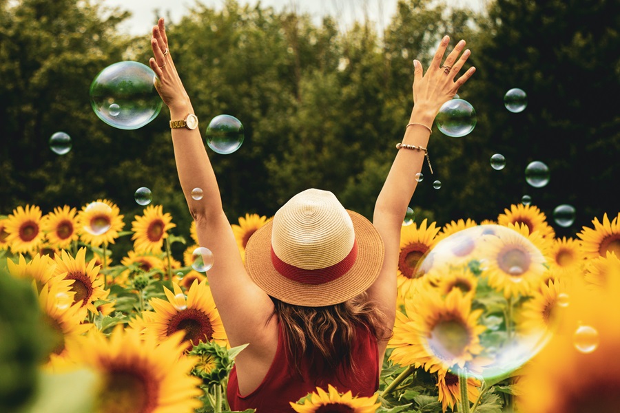 Quotes About Surrounding Yourself with Happiness a Woman Standing in a Field of Sunflowers with Her Hands Up in the Air