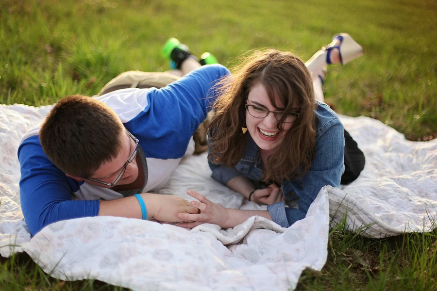 Funny Smartass Quotes About Relationships a Couple Laughing Together While Lying Down on a Blanket on a Field