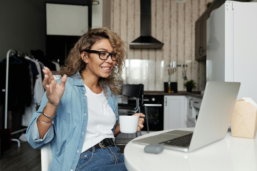 How to Start Your Day a Woman Sitting at a Kitchen Table Having an Active Conversation with Someone on a Lap Top