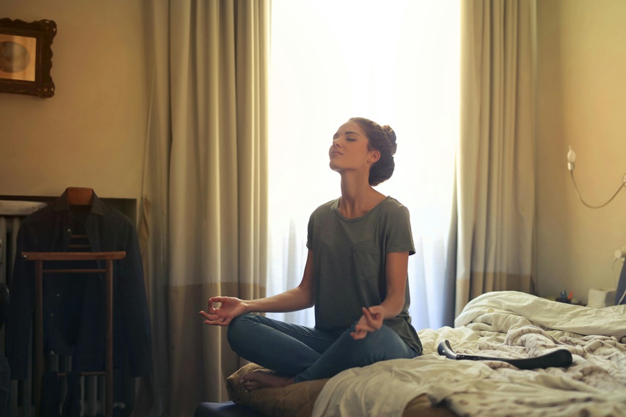 How to Start Your Day a Woman Sitting on the Foot of Her Bed Meditating