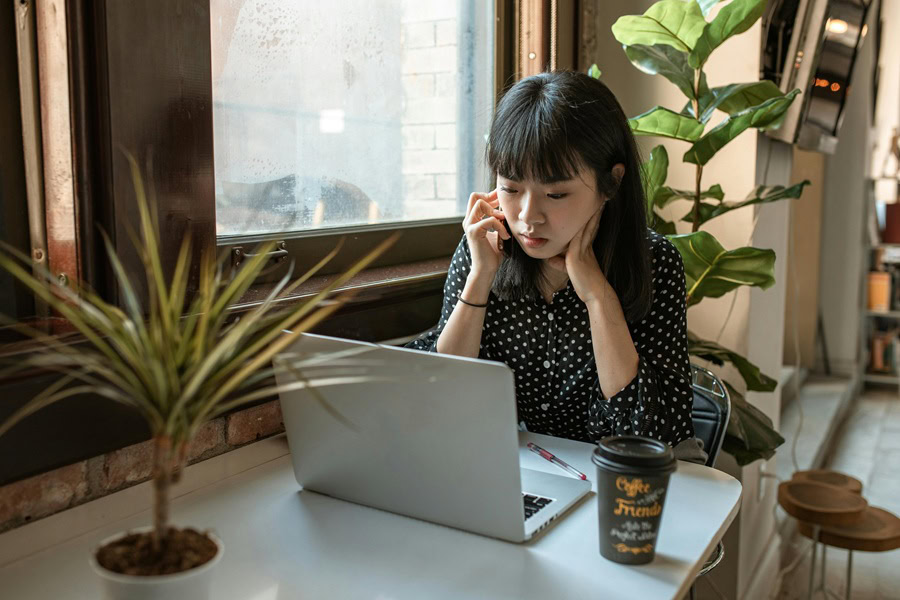 Powerful Quotes For Entrepreneurs a Woman Sitting at a Table with a Laptop While Talking on a Phone