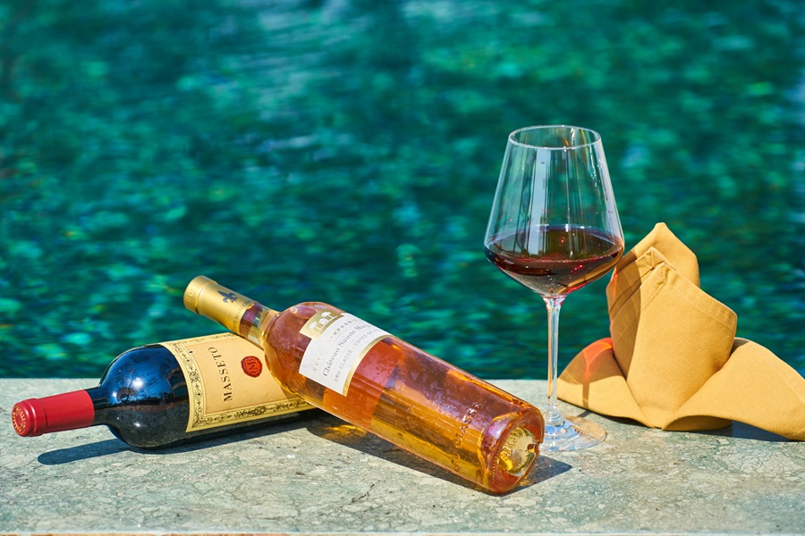 Summer Decorations for an Outdoor Party to Remember Close Up of Wine Bottles and a Wine Glass Next to a Pool