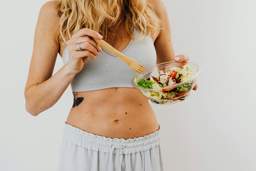 Clean Eating Tips for Beginners a Woman Eating a Salad from a Salad Bowl