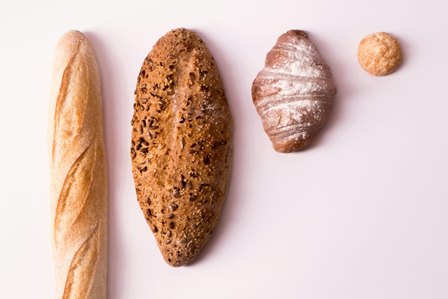 Gluten Free Diet Benefits 4 Different Types of Bread in a Line on a Counter Top