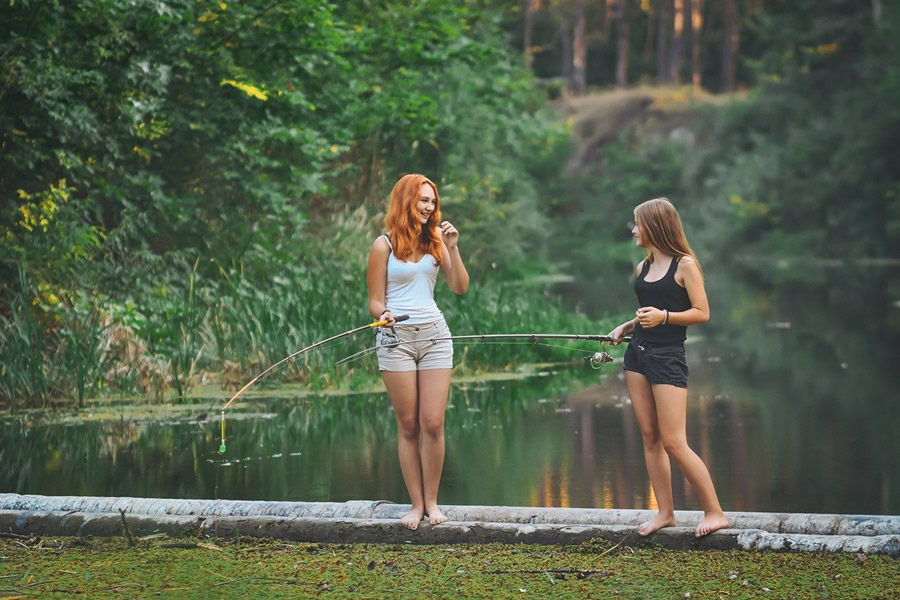 Best Summer Captions for Instagram Two Girls Standing in a Lake Fishing
