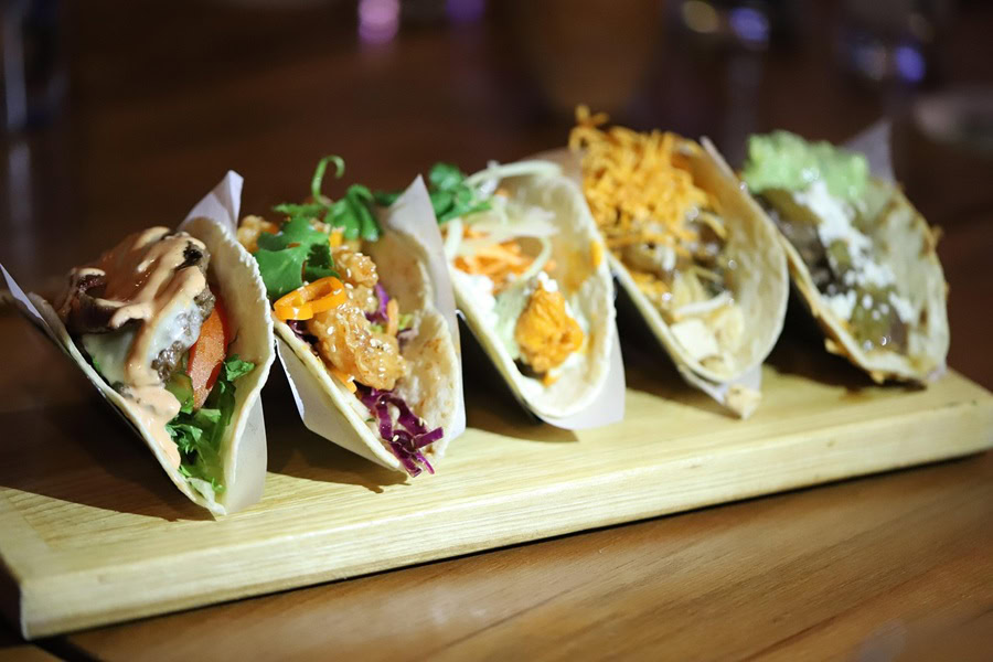 Best Taco Tuesday Recipes 5 Tacos on a Taco Stand on a Wooden Cutting Board on a Wooden Table