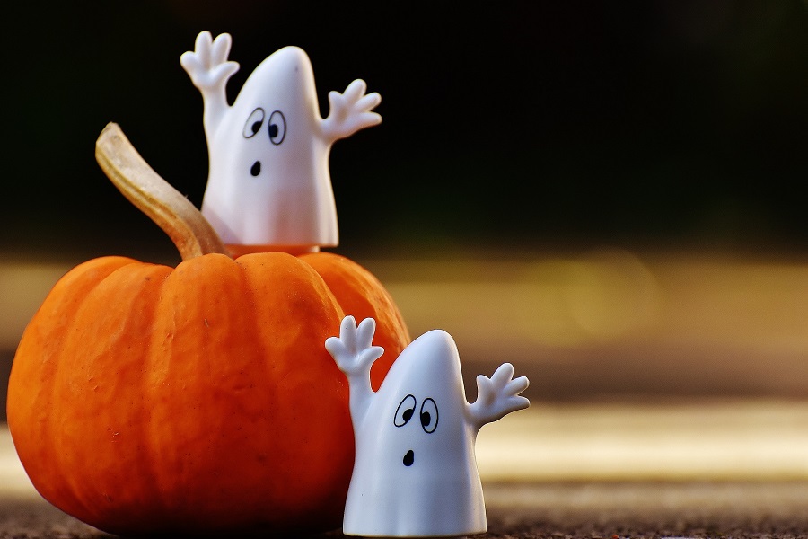 DIY Halloween Decorations Three Small Toy Ghost Figures Sitting on a Pumpkin