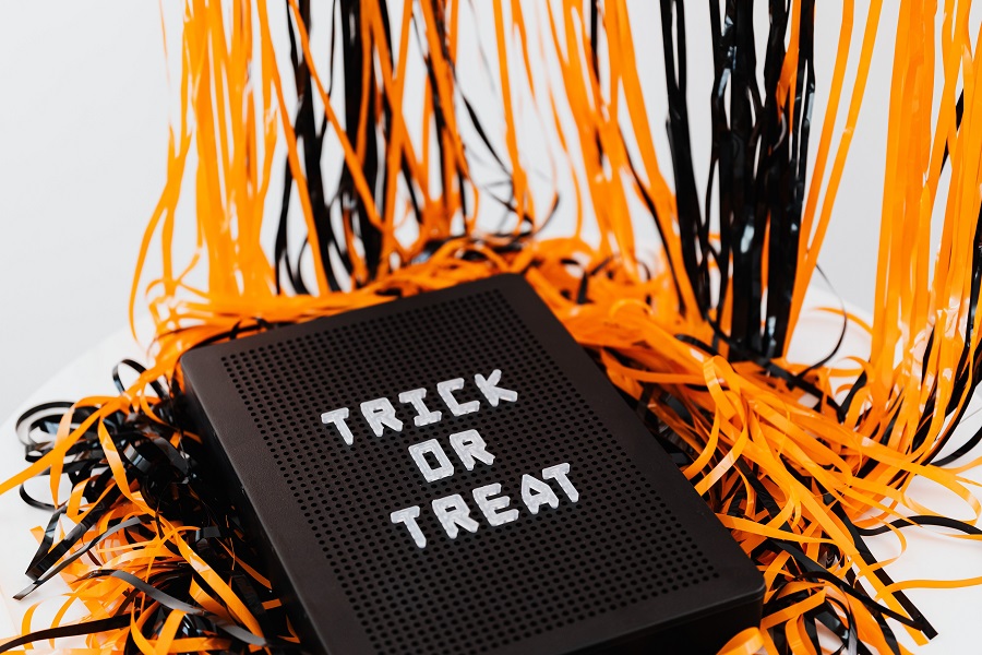 DIY Halloween Decorations Close Up of a Letterboard with Trick or Treat on It and Orange and Black Streamers in the Background
