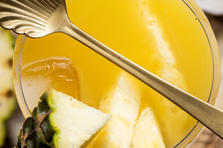 Banana Creme Rum and Orange Juice Cocktail Overhead View of a Glass Filled with the Cocktail and a Spoon Laying Across the Glass