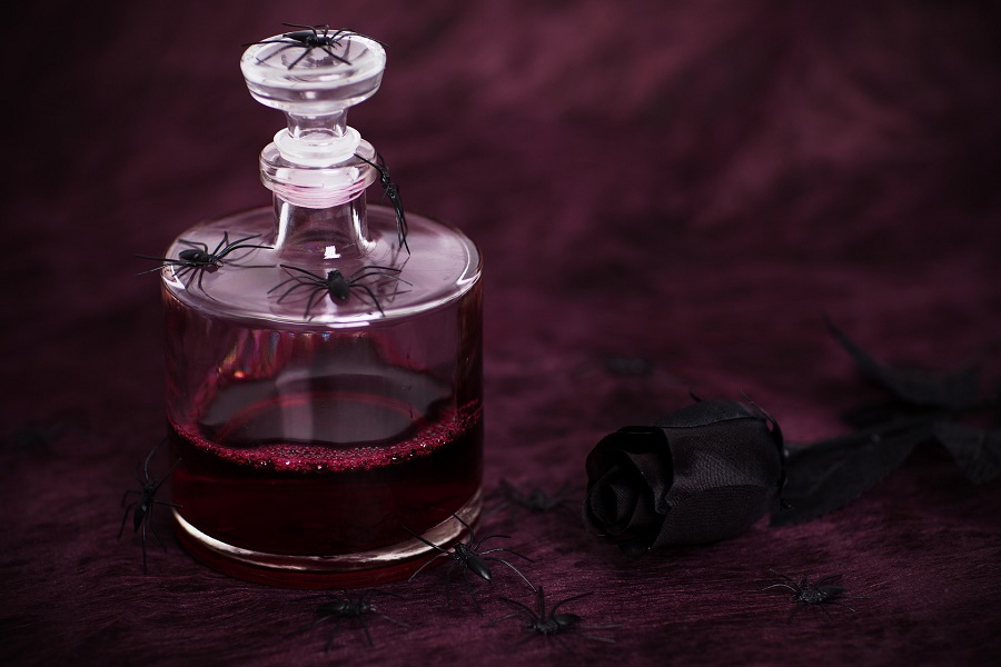 Halloween Virgin Party Drinks Close Up of a Bottle of Red Liquid with Spiders Around it