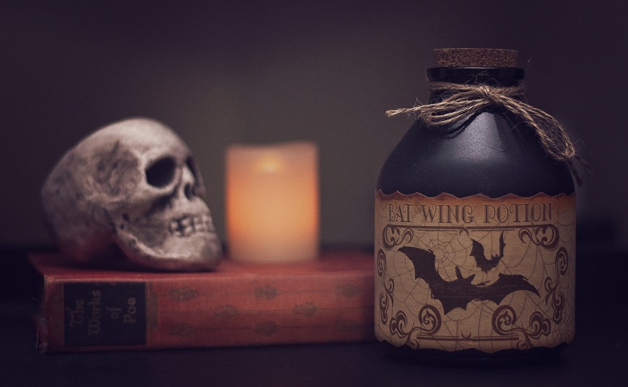 Halloween Virgin Party Drinks A Jar with a Old Label on it With Bats and a Skull in the Background Next to a Lit Candle