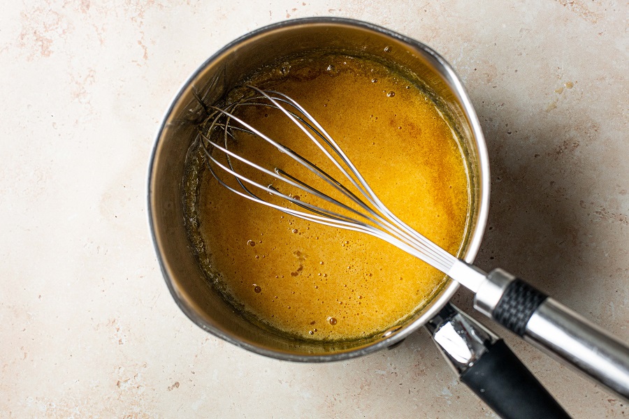 Homemade Spiked Eggnog with Bourbon Recipe Overhead View of a Pot with a Whisk and the Custard Ingriedients