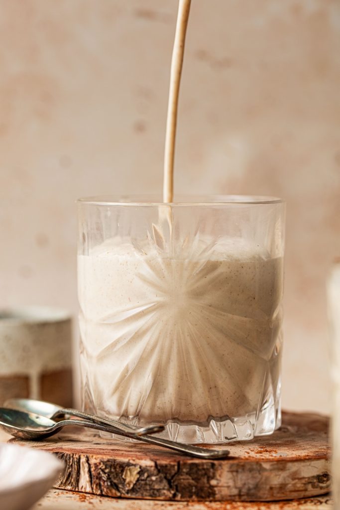 Homemade Spiked Eggnog with Bourbon Recipe Eggnog Being Poured into a Glass From Above