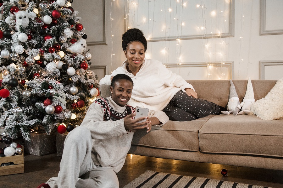 Christmas Tree Ideas Couple Sitting on a Couch Next to a Christmas Tree