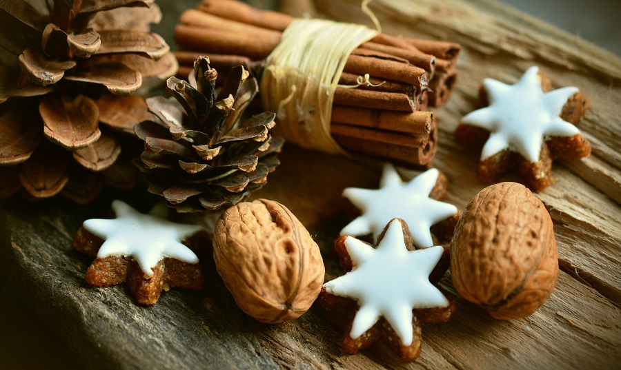 DIY Christmas Decor Ideas Close Up of a Bundle of Cinnamon Sticks Next to Walnuts and Pinecones and Cookie Stars