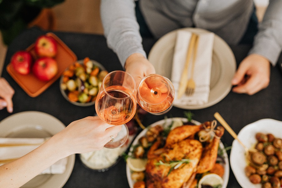 Air Fryer Thanksgiving Sides Overhead View of a Thanksgiving Dinner Table with People Toasting Above the Food