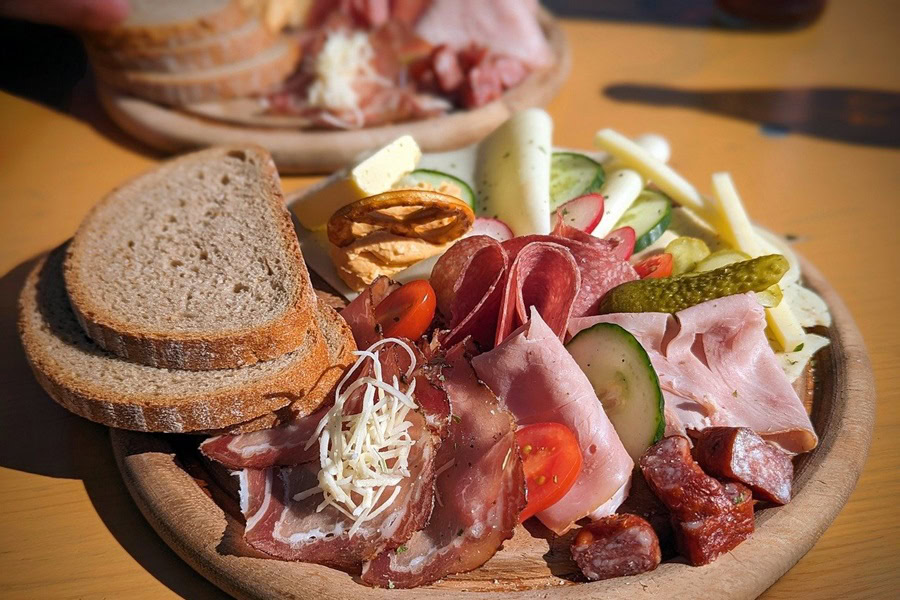 How to Make a Charcuterie Board Close Up of a Charcuterie Board with Meat, Cheese, and Bread on a Table Outdoors