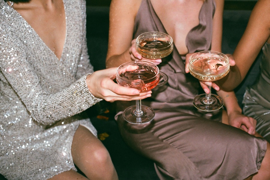 New Years Eve Outfits a Group of Women Clinking Cocktail Glasses Together Dressed Nicely for a Party