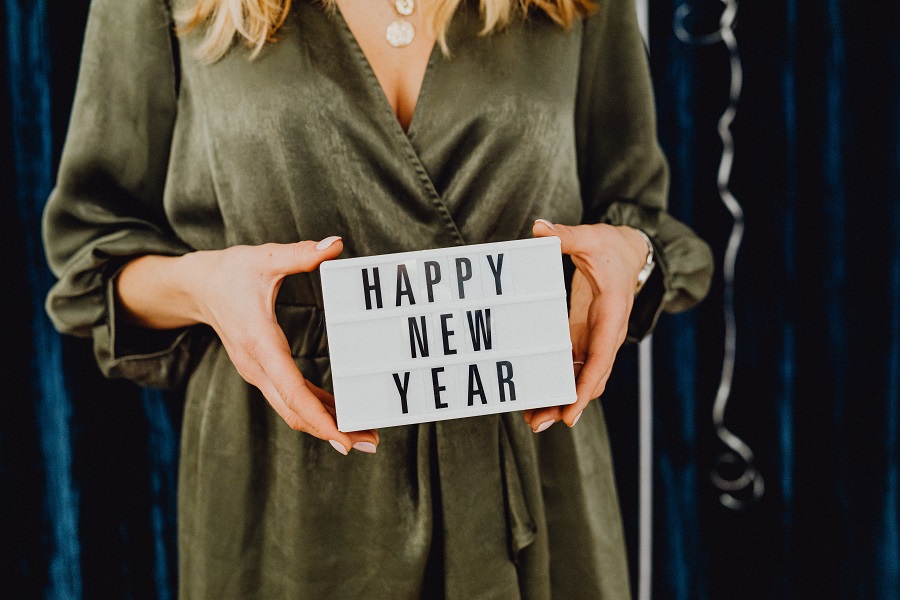 New Years Eve Outfits Close Up of a Woman Holding a Letter Board That Says Happy New Year