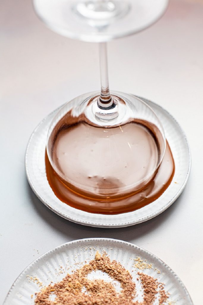 Pumpkin Spice Mocktail Glass Being Dipped in Caramel