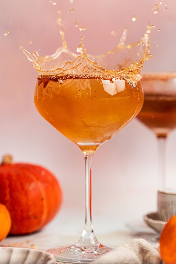 Pumpkin Spice Mocktail Close Up of a Glass of Mocktail with the Drink Being Splashed Out From the Top