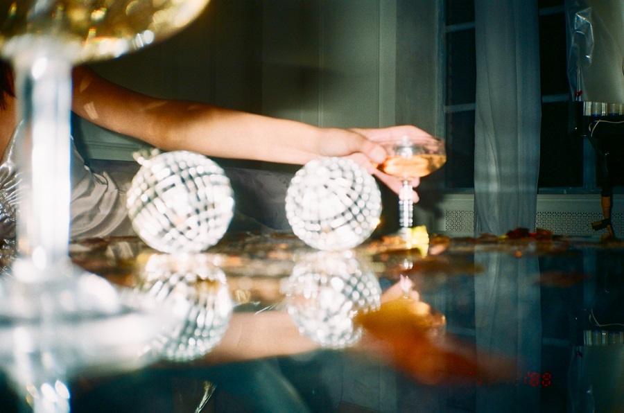 DIY New Years Eve Decor  Close Up of Someone Reaching for a Glass of Champagne with Decor on the Table