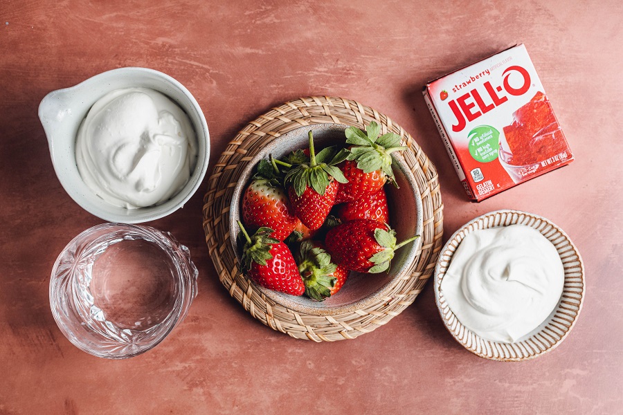 Easy Santa Hat Jello Shot Recipe Ingredients Including Red Jello, Strawberries, Cool Whip and Whipped Cream