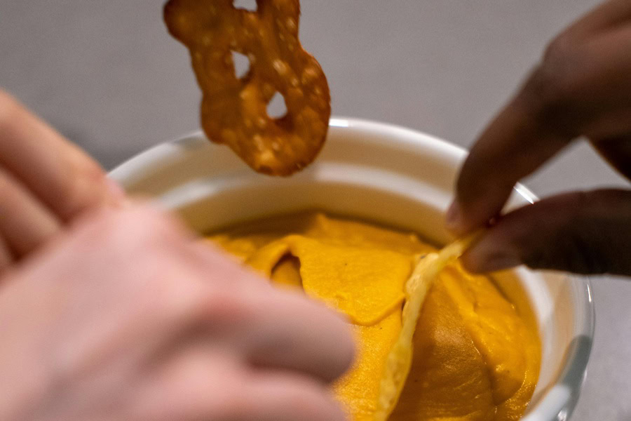 Beer Dip for Pretzels Close Up of Hands Dipping Different Foods into Cheese Dip in a Small Ramekin