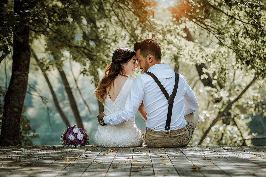 Valentines Photoshoot Ideas Couple Sitting Together Outside Dressed Up With Their Heads Placed Together