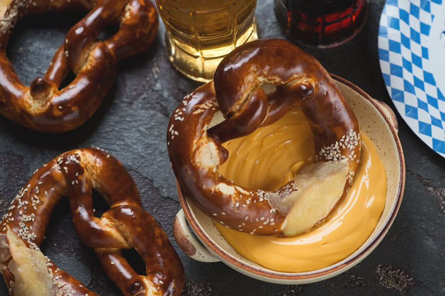 Beer Dip for Pretzels a Soft Pretzel Sitting in a Small Bowl of Cheese Dip Next to a Beer