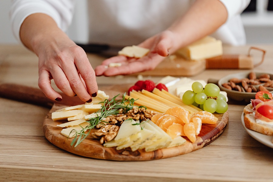 Game Day Charcuterie Board Ideas Close Up of a Person Putting Together a Cheese Board