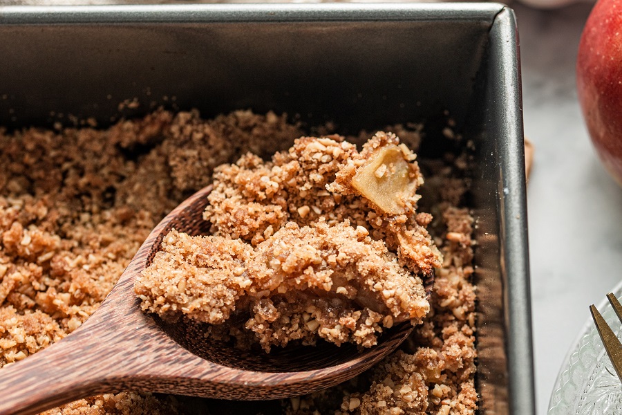 Apple Crisp with Oats Dessert Close Up of Apple Crisp in a Baking Pan with a Serving Spoon
