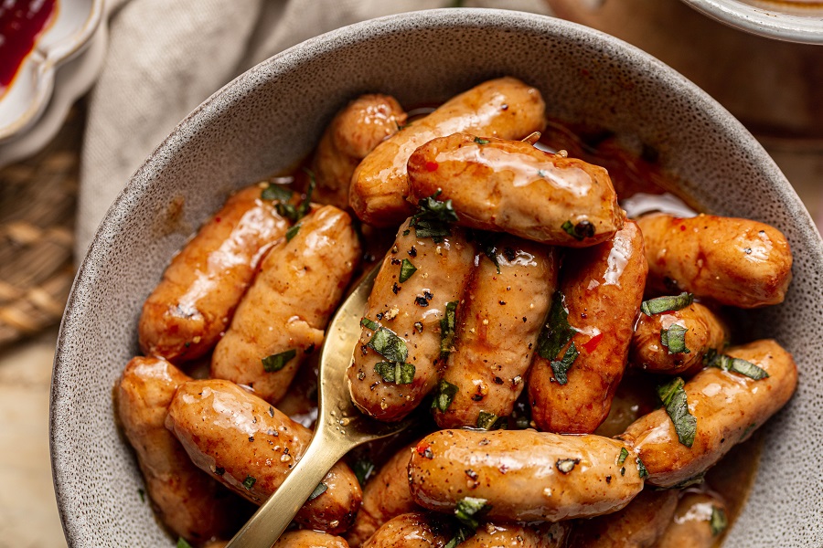 Little Smokies Party Recipe Close Up of a Bowl of Little Smokies Garnished with Green Onions